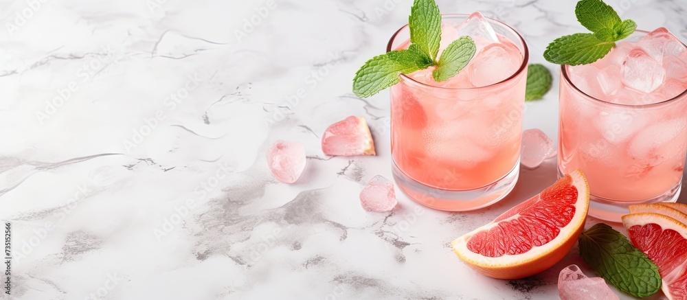 Aufkleber preparation of a grapefruit alcohol free cocktail several tumbler glasses with ice cubes on marble s