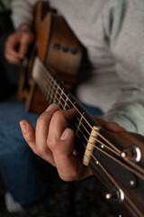 A closeup shot of a man's hand playing the guitar
