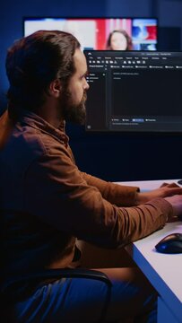 Computer scientist developing code on PC while in apartment office using java programming languages. IT admin brainstorming ways of fixing database errors while working from home, camera B