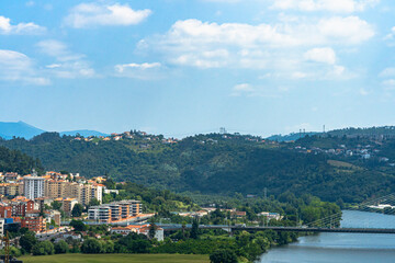 Fototapeta na wymiar A view of Coimbra City under a beautiful clear sky, with Mondego River, trees, and buildings. Landscape background and wallpaper.