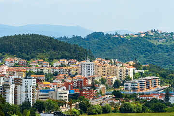 Fototapeta na wymiar A view of Coimbra City under a clear sky, with trees and buildings. Landscape background and wallpaper.