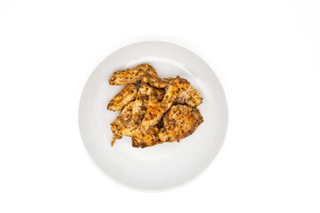 Homemade roasted chicken-breast fillet marinated with herbs and spices, served on a white plate. Isolated on white with copy space. Top view or flat lay.
