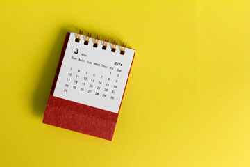 Desk calendar for March 2024 on a yellow background, with copy space.