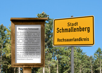 Fototapeta na wymiar Komposition; Ortstafel mit einem Infotafel Ökosystem Fichtenwald, in Schmallenberger Sauerland