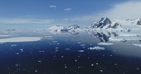 Blue Antarctic seascape at glacier coast aerial. Icebergs floating at arctic ocean bay. Melting ice and snow of Antarctica at global warming message. Environment preservation and climate change