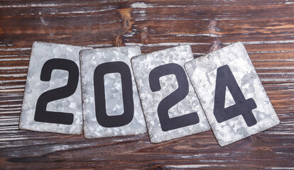 The metal year 2024 text on wooden card
