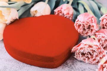 Obraz na płótnie Canvas Heart-shaped red velvet gift box with beautiful tulips on gray background,
