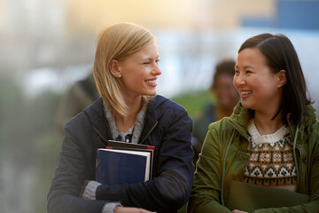 Education, books and talking with woman friends outdoor on campus together for learning or development. Diversity, college or university with young student and best friend chatting at recess break