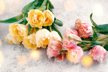 yellow tulips and pink tulips on a gray concrete background. Bouquet for a gift. Festive congratulations on Mother's Day, March 8, Birthday and Valentine's Day