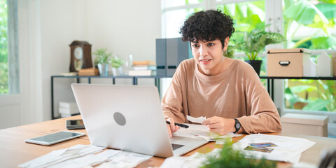 A Young Asian businesswoman is checking financial documents, calculating bills or taxes expense or...