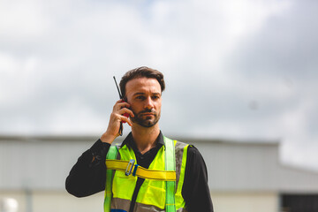 A Professional engineer or expert technician using radio communication or walkie-talkie to order...