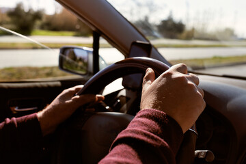 Close-up of a male hands on a steering wheel