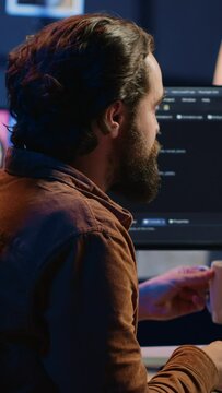 Stressed engineer feeling pressed by deadline, thinking how to finish developing code on PC. IT specialist brainstorming ways of solving database errors, working hard, drinking coffee, camera A