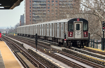 subway train on elevated track in the bronx with high rise apartment buildings in the background...