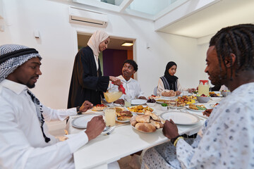 In the sacred month of Ramadan, a Muslim family joyously comes together around a table, eagerly...