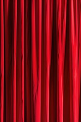 A close-up view of a vibrant red curtain hanging in a room.