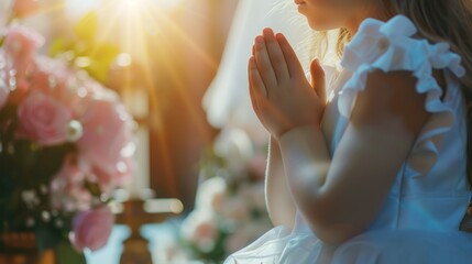 A young girl, during her first communion, folded her hands in prayer against the backdrop of the church. Reflecting the importance of faith and prayer in the modern world.