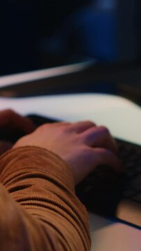 Computer scientist listening music while writing lines of code during remote job shift in home office. IT specialist enjoying audio podcast, coding on desktop PC, camera A extreme close up