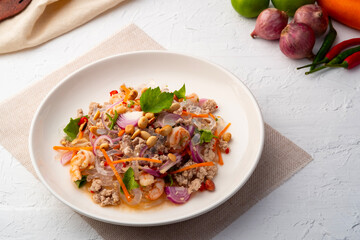 Spicy Glass Seaweed noodle Salad with Minced Pork (yum sen kaew) is a type of Thai salad made with clear Kelp noodle and meat in white plate © Kritchai