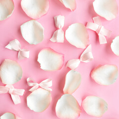 White rose petals on pastel pink background. Valentines Day or Wedding concept. Beautiful greeting card