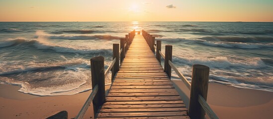 Wooden walkway in the middle of the beach with the blue sea - obrazy, fototapety, plakaty