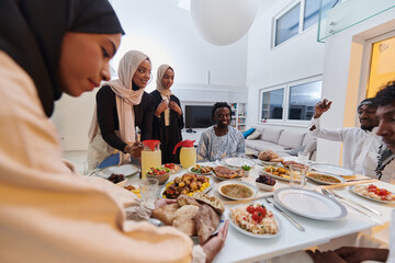In the sacred month of Ramadan, a Muslim family joyously comes together around a table, eagerly awaiting the communal iftar, engaging in the preparation of a shared meal, and uniting in anticipation