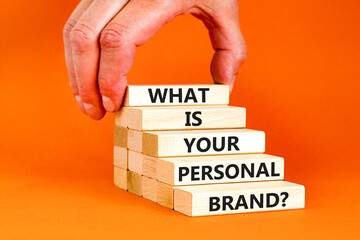 What is your personal brand symbol. Concept words What is your personal brand on wooden blocks. Beautiful orange background. Businessman hand. Business, what is your personal brand concept. Copy space