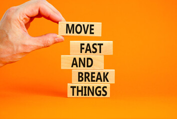 Move fast and break things symbol. Concept words Move fast and break things on wooden blocks. Beautiful orange background. Businessman hand. Business, move fast and break things concept. Copy space.