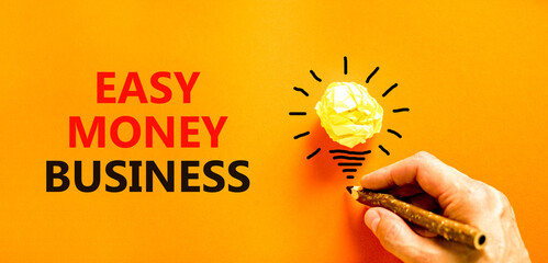 Easy money business symbol. Concept words Easy money business on beautiful orange paper. Beautiful orange background. Light bulb icon. Businessman hand. Easy money business concept. Copy space.