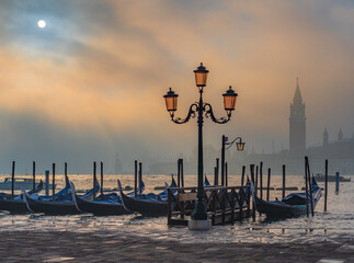 Gondolas in Venice at sunrise in morning fog. Veneto, Italy.. - 735231720