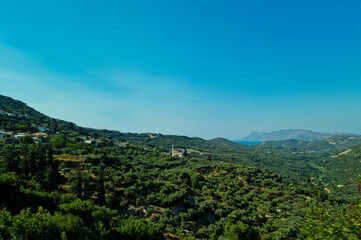 Beautiful view on the island of Crete in Greece. A landscape of olive orchards, mountains and the Mediterranean Sea in the distance. Sunny weather in Crete and plenty of space