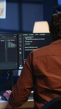 Admin using javascript coding language to fortify security and safeguard consumer data, remotely working for IT company. Software developer upgrading binary code scripts on computer terminal, camera A