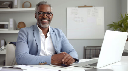 Obraz premium A professional in a light blue blazer is working on a laptop at a modern office desk, exuding confidence and satisfaction with their work.