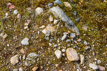 Moraine stones rounded by an ancient glacier on a sand quarry, rocky background. Kaluga region, central Russia