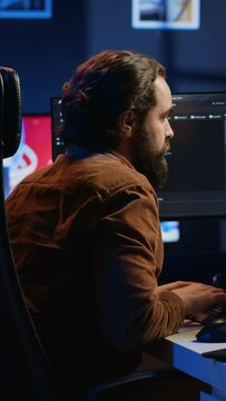 Developer pressed by deadline, drinking coffee and doing multitasking to finish developing PC code. Caffeinated IT specialist solving database error using multiple desktop and laptop screens, camera A