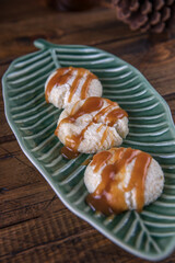 Cheesecakes with caramel sauce on a plate on a wooden table