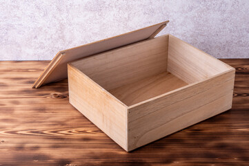 Wooden box with cover on a wooden table.