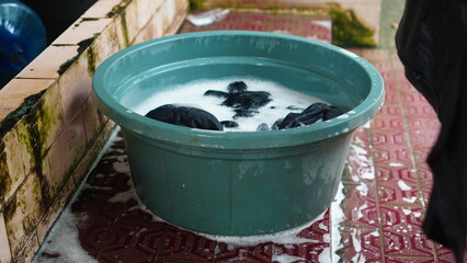 a bucket of water and dirty clothes