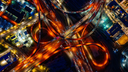 Bright illumination of roads in the downtown of Dallas, Texas, USA. Top view on the transport moving by the highways at night.
