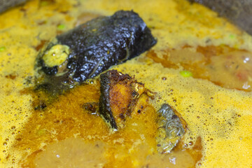 fresh cooked boiling fish gravy at cauldron at home at day