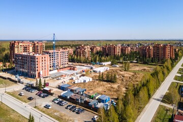 the construction site of an apartment building in the summer from a height