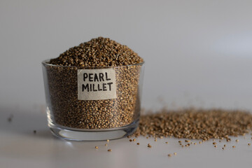 Pearl millet grains in a glass bowl with label on it filled to the brim