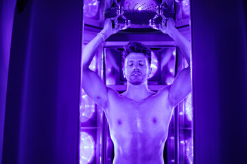 Man tanning in a uv tan booth