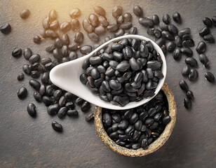 Black pepper seeds in wooden bowl on dark background. Top view with copy space