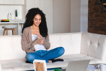 Happy smiling african woman student using cellphone online for scrolling social media, doing online shopping, remote work, ordering food delivery from application