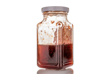 Strawberry jam in a glass jar, macro, isolated on white background.
