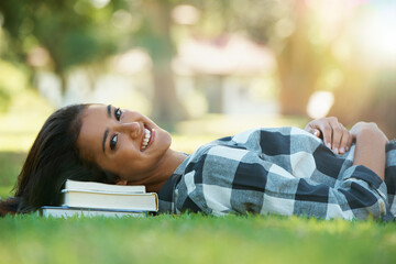 Portrait, grass or happy woman in park with books for learning knowledge, information or education. Smile, textbook or student in nature for studying break or peace on college campus lawn to relax