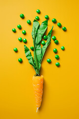 paper carrot on a yellow background with green sweets - obrazy, fototapety, plakaty