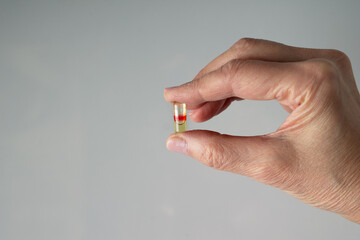 The woman's hand holds one pill, a copy of the space
