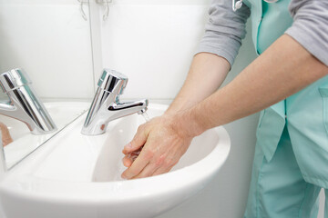 doctor washing hands at medical clinic sink